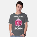 Model wearing charcoal Adulting Is A Scam – Coffee Graphic T-Shirt