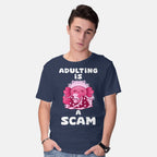 Model wearing navy Adulting Is A Scam – Coffee Graphic T-Shirt