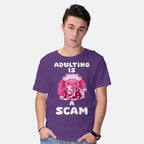 Model wearing purple Adulting Is A Scam – Coffee Graphic T-Shirt